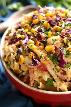 a red bowl filled with corn salad and garnished with cilantro