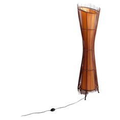 a floor lamp made out of bamboo sticks with a wire attached to the base and an electric cord running through it