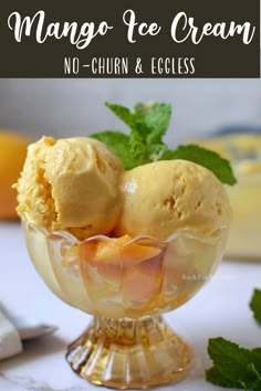 two scoops of mango ice cream in a glass bowl with mint on the side