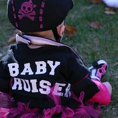 a baby wearing a pirate outfit sitting in the grass