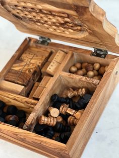 an open wooden box filled with lots of different types of wood beads and other items