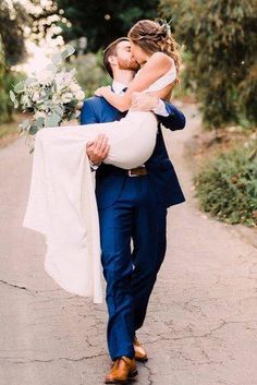 a bride carries her groom down the road for their wedding photo session at this outdoor venue