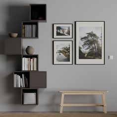 a white shelf with books and pictures on it next to a wooden bench in front of a gray wall