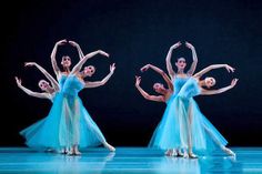 three ballerinas in blue dresses are performing on stage