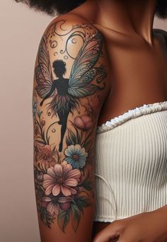 a woman's arm with flowers and a fairy tattoo on her left arm,