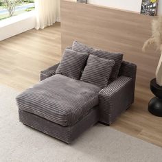 a gray couch sitting on top of a wooden floor