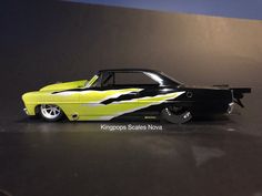 a black and yellow car with flames painted on it's side, sitting on a table