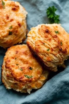 three crab cakes sitting on top of a blue cloth