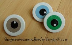 two buttons with green and blue eyes on them