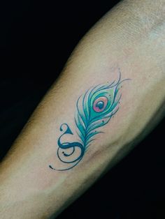 a peacock feather tattoo on the arm