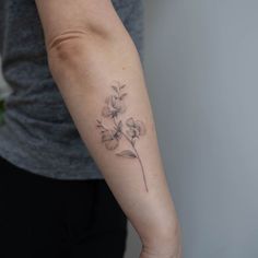 a woman's arm with a flower tattoo on the left side of her arm