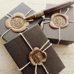 two gift boxes wrapped in brown paper and tied with twine, one has a wax stamp on it