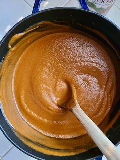 a wooden spoon in a pan filled with peanut butter