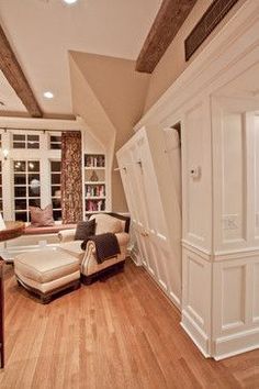 a living room with wood floors and white furniture in the middle of an open floor plan