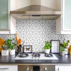 a stove top oven sitting inside of a kitchen next to a wall mounted range hood