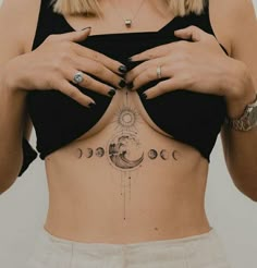 a woman's stomach with the moon and phases tattooed on it