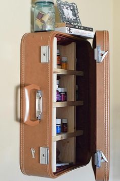 an open suitcase with medicine bottles in it on top of a shelf next to a wall