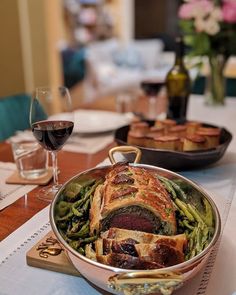 a table topped with lots of food and glasses of wine