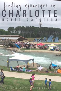 there are many people on the grass by the water and in the background is a sign that says finding adventure in charlotte, north carolina