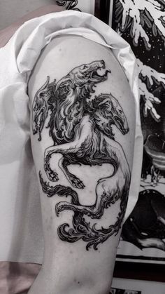 a black and white photo of a man's arm with a dragon tattoo on it