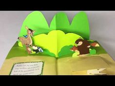 an open book with animals on it and a paper card in the middle that says,