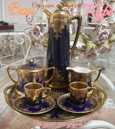 there is a blue and gold tea set on the table