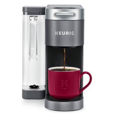 the keurig single serve coffee maker is shown with its red cup in front of it