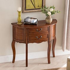 a wooden table with flowers on it and a painting in the corner next to it