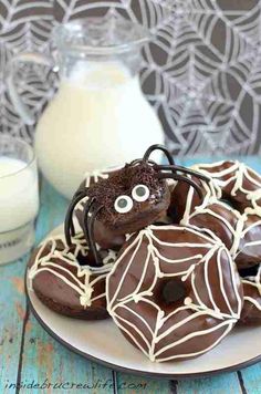 chocolate spider cookies on a plate with milk