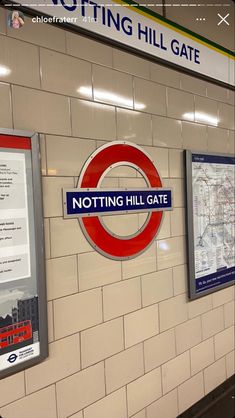 there is a sign that says notting hill gate on the wall next to it