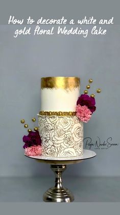 a three tiered wedding cake with gold and white frosting on a silver stand