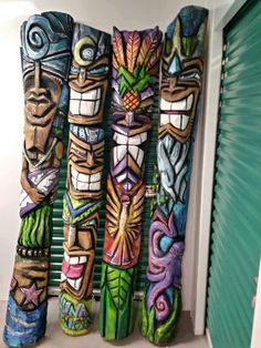 several colorfully painted totemas are lined up against a window