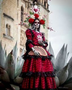 a woman dressed in red and black with flowers on her head