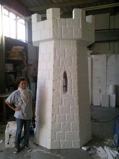 a woman standing next to a white tower