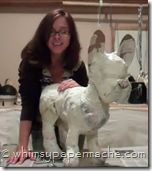 a woman is holding a white dog statue