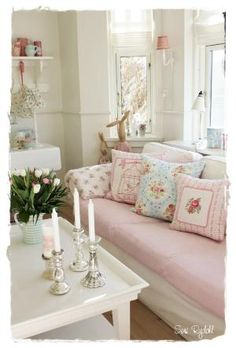 a living room filled with lots of furniture and flowers on top of a white table