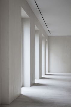 an empty room with white walls and columns