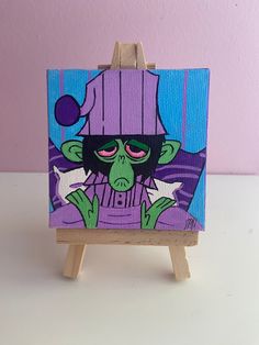 a small easel with a painting of a cartoon character on it's side