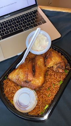 an open laptop computer sitting on top of a table next to a plate of food