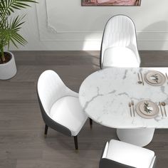 a white marble dining table with four chairs around it and a potted plant in the corner