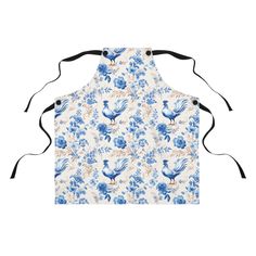 an apron with blue flowers and roosters on it, hanging from the back of a white