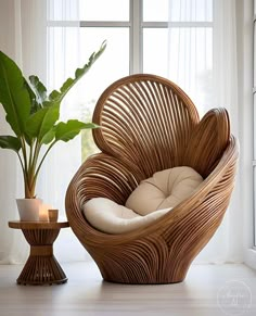 a wicker chair sitting next to a potted plant in front of a window