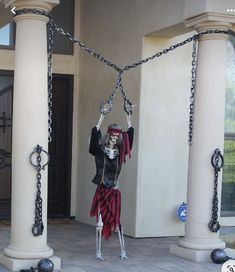 a skeleton hanging from chains in front of a house