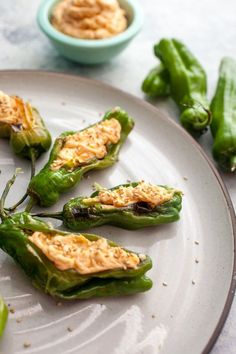 some green peppers on a white plate with sauce