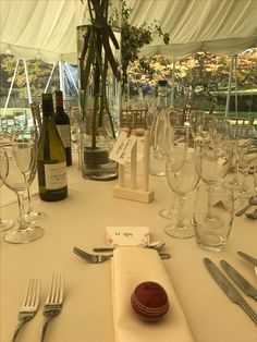 a table set up with wine glasses, silverware and a cricket ball on it