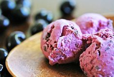 two scoops of blueberry ice cream on a wooden plate