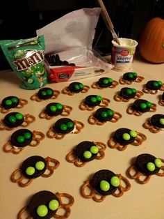 a table topped with pretzels and green candies on top of pretzels