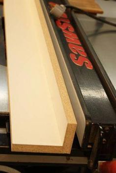 a close up of a piece of wood on top of a table with scissors and tape