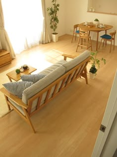 a living room filled with furniture next to a wooden table and chairs on top of a hard wood floor