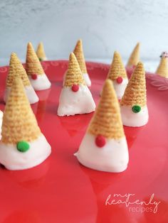 small cones with candy on them sitting on a red plate